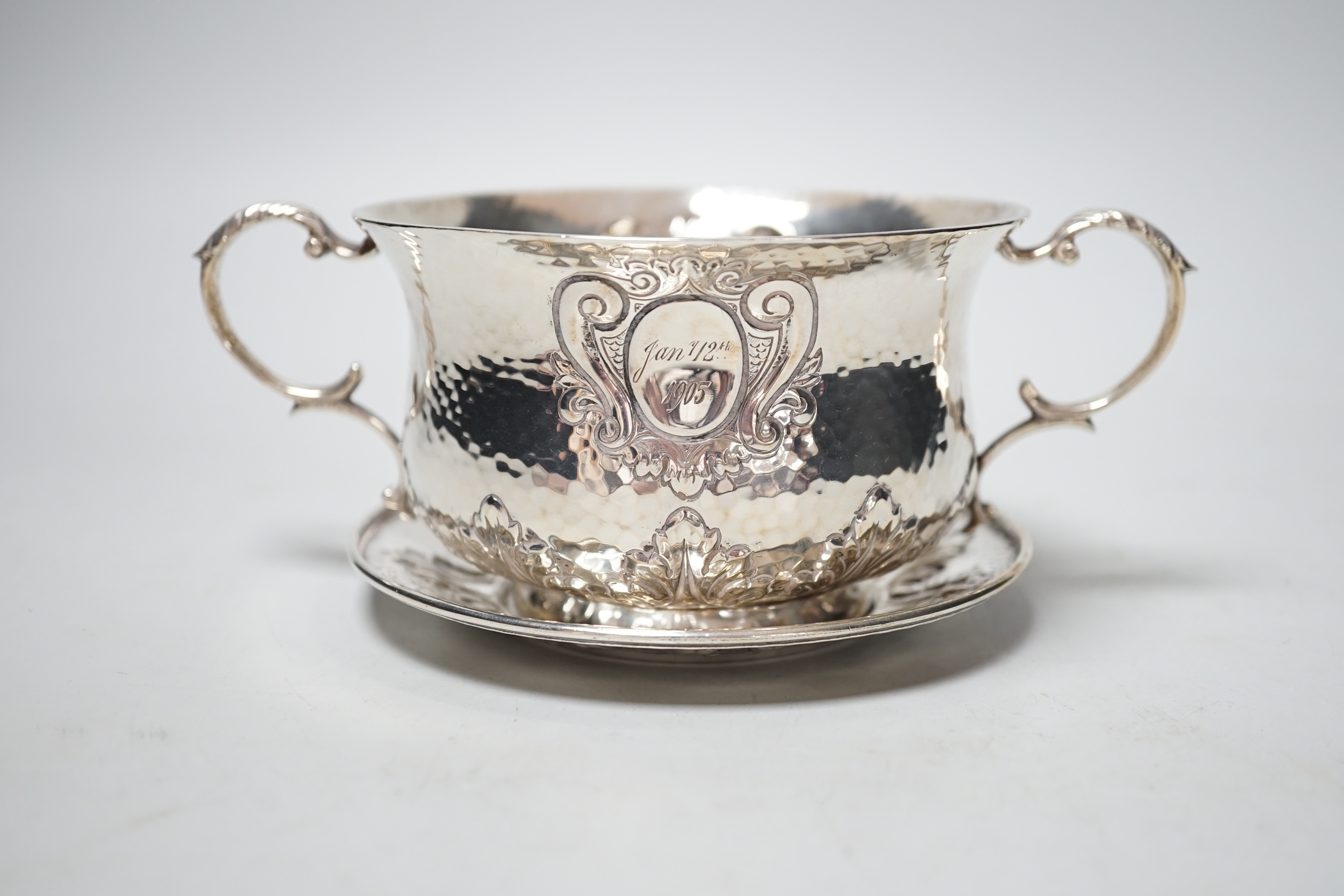 An Edwardian hammered silver two handled porringer on stand, Elkington & Co, London, 1903, diameter 17.7cm over handles, 10.9oz.